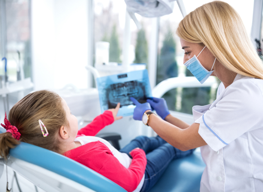 dental worker showing little girl her x-ray