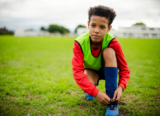 boy tying shoes before playing a sport