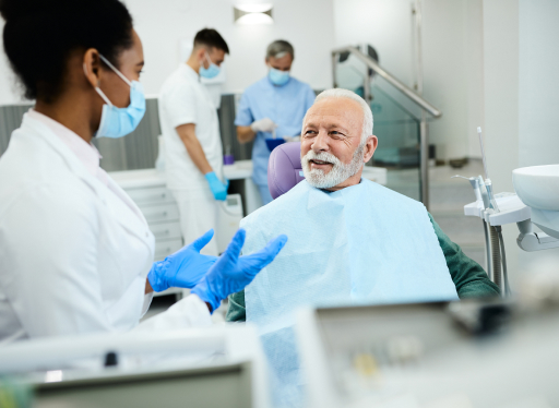 old man being talked to by a dental worker